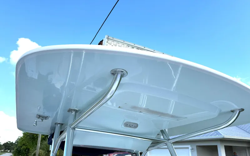 Slide: The Image of 2015 Bluewater 2550 boat's T-top with stainless steel supports under clear blue sky. - 9