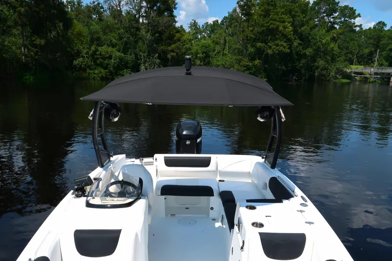 Slide: The Image of 2017 Tahoe 2150 boat on a calm lake with lush green trees. - 10