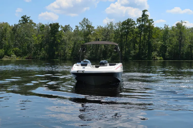 Slide: The Image of 2017 Tahoe 2150 boat on a calm lake with forested background. - 2