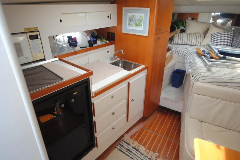 Slide: The Image of 1996 Tiara Yachts 3100 Open interior with kitchenette, sink, and cozy sleeping area. - 11