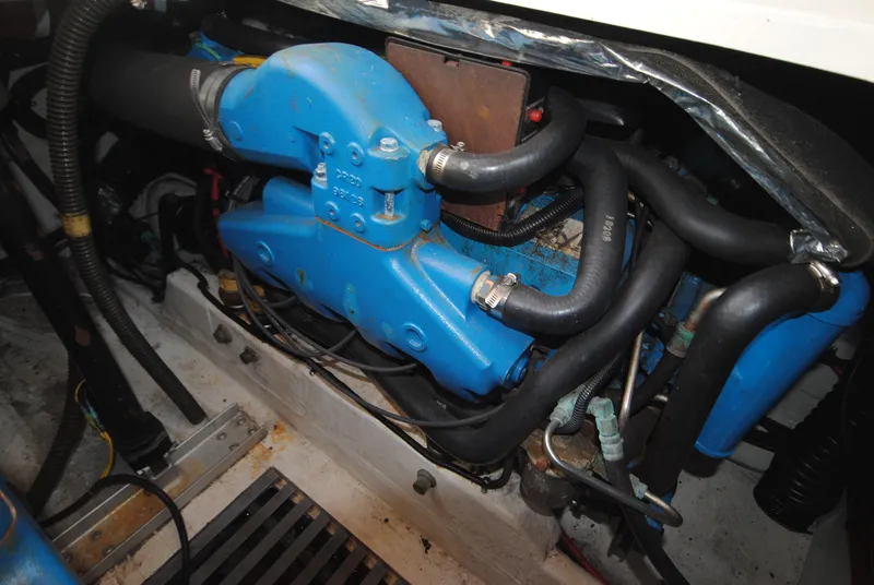 Slide: The Image of Engine compartment of a 1996 Tiara Yachts 3100 Open, featuring blue components and hoses. - 16