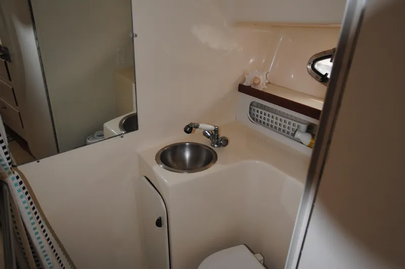 Slide: The Image of 1996 Tiara Yachts 3100 Open bathroom with sink, mirror, and storage shelf. - 18
