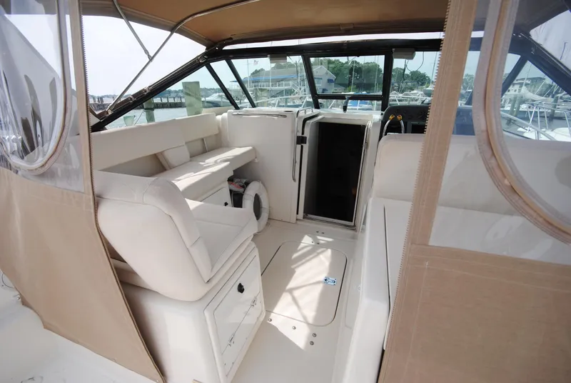 Slide: The Image of 1996 Tiara Yachts 3100 Open interior with beige seating and helm station. - 5
