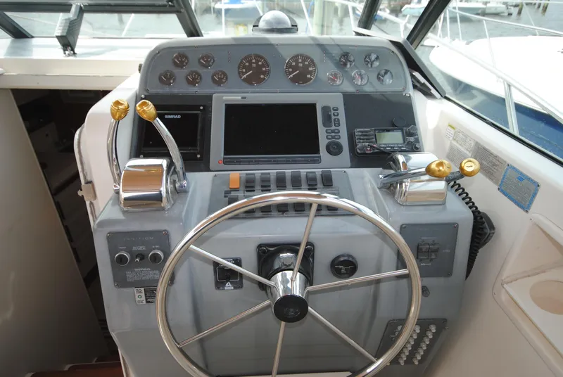 Slide: The Image of 1996 Tiara Yachts 3100 Open helm with steering wheel and navigation controls. - 9