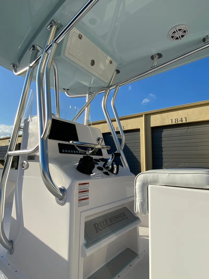 Slide: The Image of 2026 Reef Runner 230 boat console with stainless steel rails and storage compartments. - 4