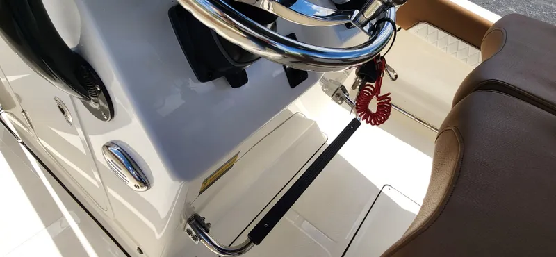 Slide: The Image of 2025 Pioneer 202 Islander boat interior with steering wheel and brown seating. - 12