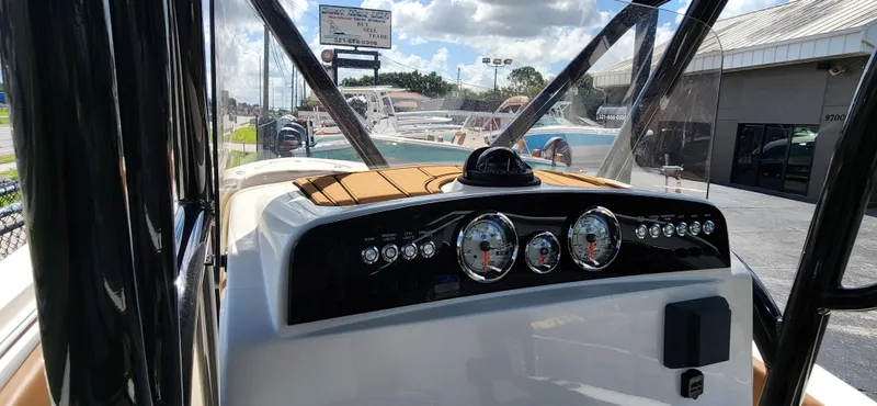 Slide: The Image of 2025 Pioneer 202 Islander boat dashboard with gauges and controls, docked under a sunny sky. - 13