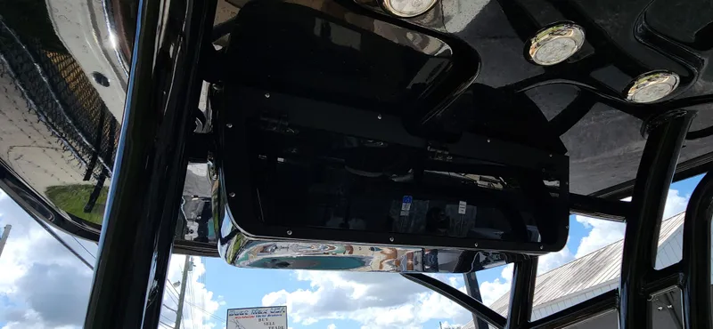 Slide: The Image of 2025 Pioneer 202 Islander boat console with sleek black finish and overhead lighting. - 14