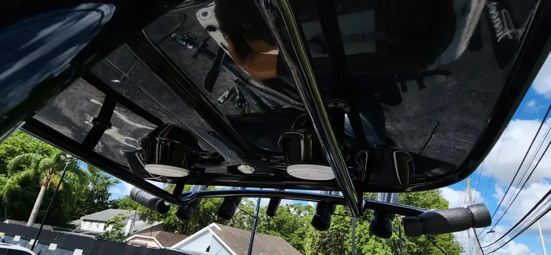 Slide: The Image of 2025 Pioneer 202 Islander boat roof with mounted speakers and rods, under a clear blue sky. - 15