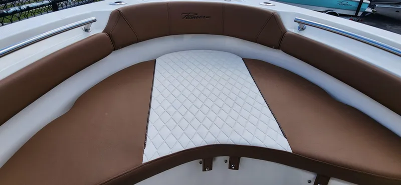 Slide: The Image of 2025 Pioneer 202 Islander boat interior with brown and white cushioned seating. - 17