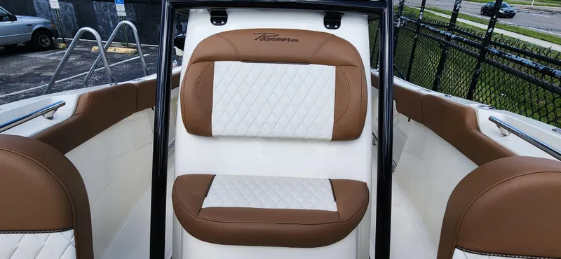 Slide: The Image of 2025 Pioneer 202 Islander boat interior with brown and white cushioned seating. - 18