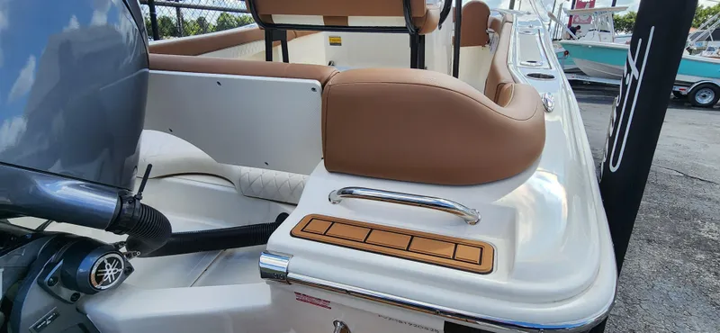 Slide: The Image of 2025 Pioneer 202 Islander boat with tan seating and Yamaha engine, docked outdoors. - 4