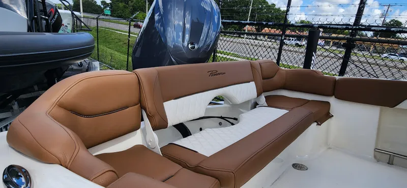 Slide: The Image of 2025 Pioneer 202 Islander boat interior with brown and white seating, outdoor display. - 5