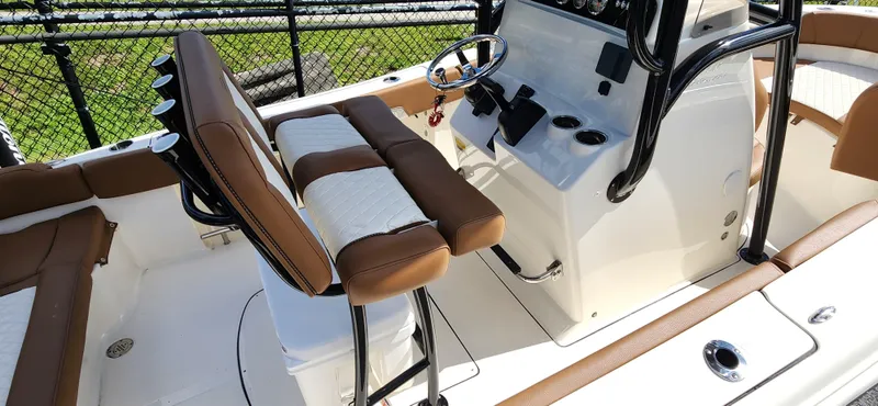 Slide: The Image of 2025 Pioneer 202 Islander boat interior with brown and white seating, steering console, and cup holders. - 8