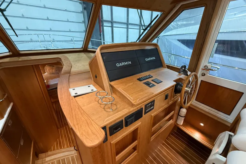 Slide: The Image of 2026 Sabre 45 Salon Express helm with Garmin displays and wooden interior. - 18
