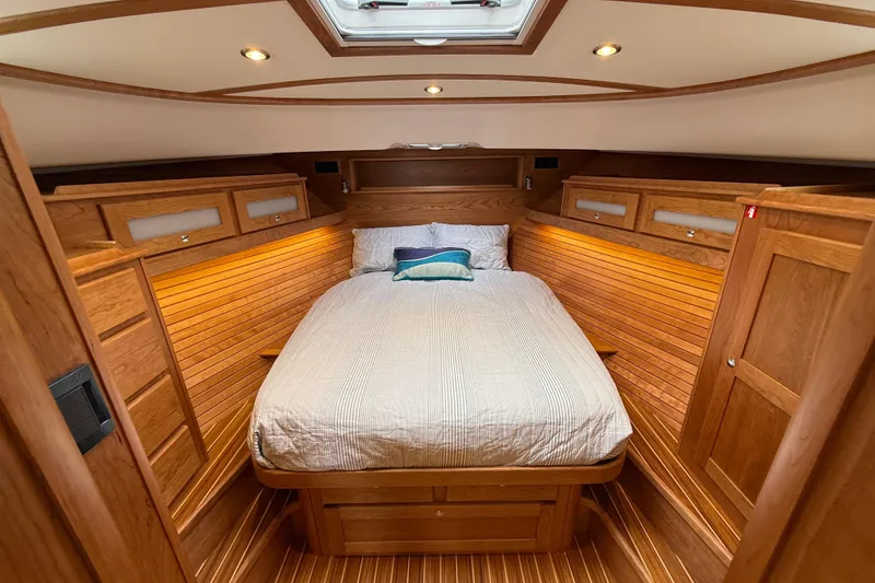 Slide: The Image of Luxurious 2026 Sabre 45 Salon Express cabin with elegant wood finish and cozy bedding. - 31