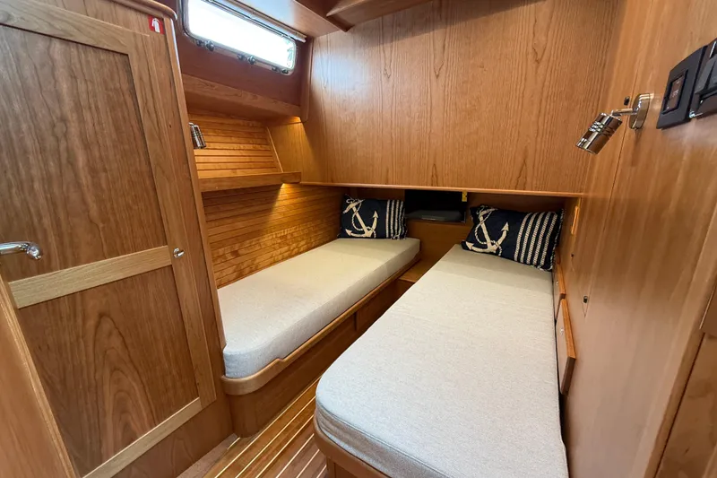Slide: The Image of 2026 Sabre 45 Salon Express cabin with twin beds and nautical decor. - 32