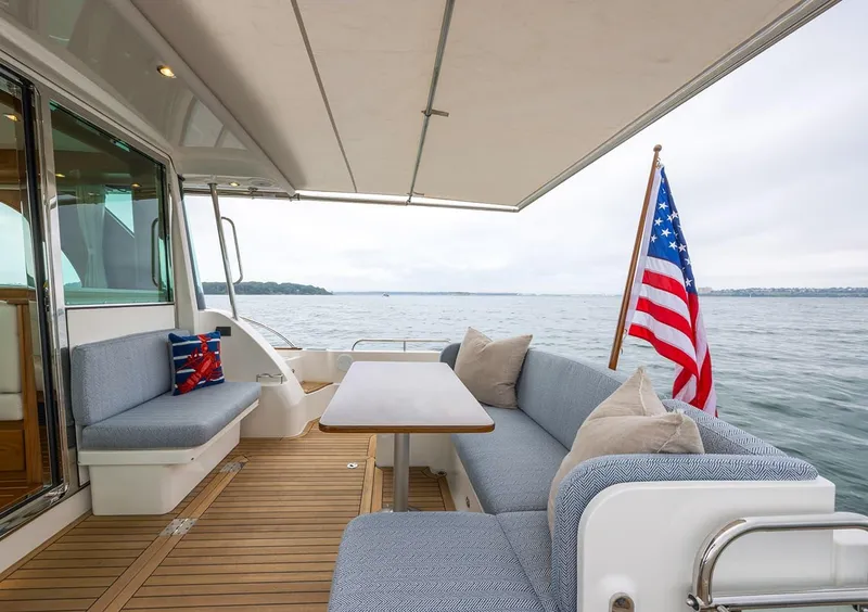 Slide: The Image of Luxury deck of 2026 Sabre 45 Salon Express yacht with seating and American flag. - 5