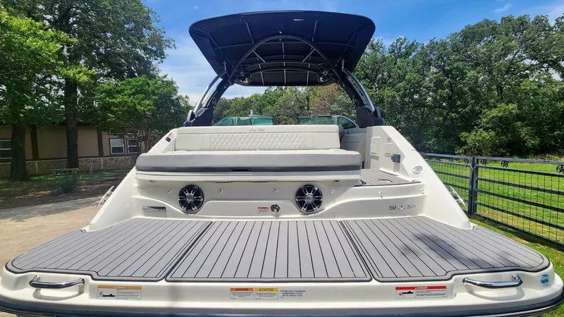 Slide: The Image of 2021 Sea Ray SLX 250 boat with spacious deck and seating, parked outdoors. - 10