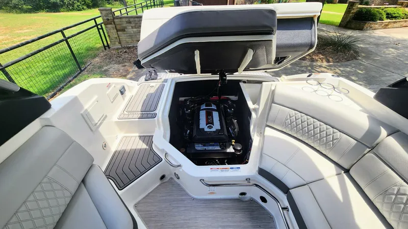 Slide: The Image of 2021 Sea Ray SLX 250 boat interior with open engine compartment and luxurious seating. - 17