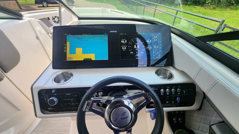 Slide: The Image of 2021 Sea Ray SLX 250 dashboard with Simrad display and steering wheel. - 2
