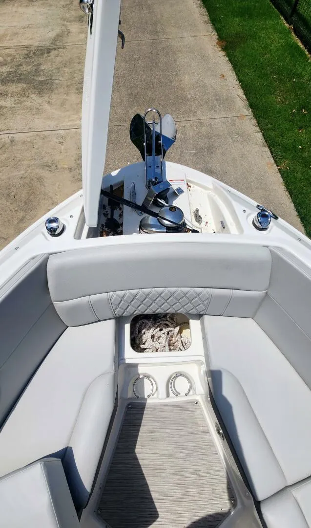Slide: The Image of 2021 Sea Ray SLX 250 boat interior with open anchor storage and cushioned seating. - 22