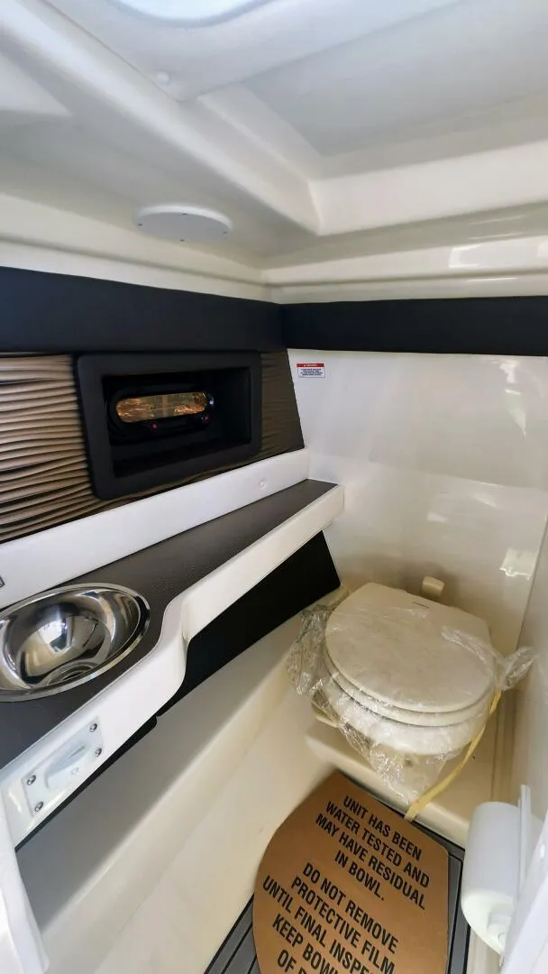 Slide: The Image of 2021 Sea Ray SLX 250 boat interior with compact bathroom and sink. - 24