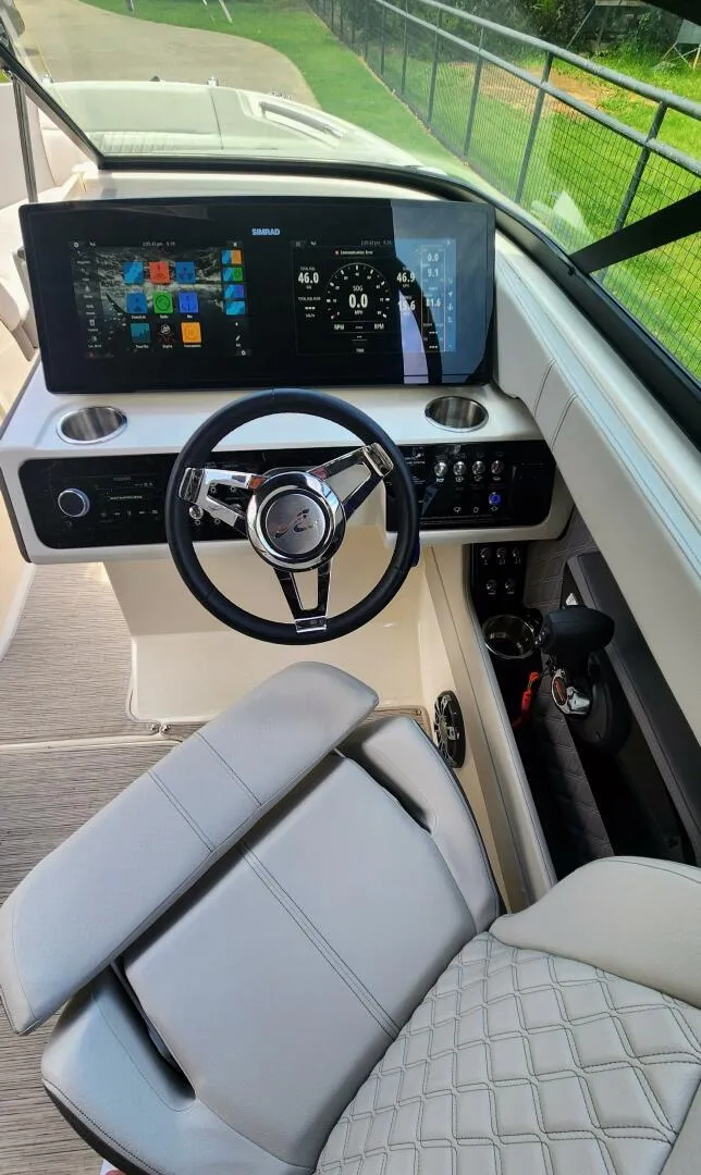 Slide: The Image of 2021 Sea Ray SLX 250 helm with modern dashboard and steering wheel. - 3
