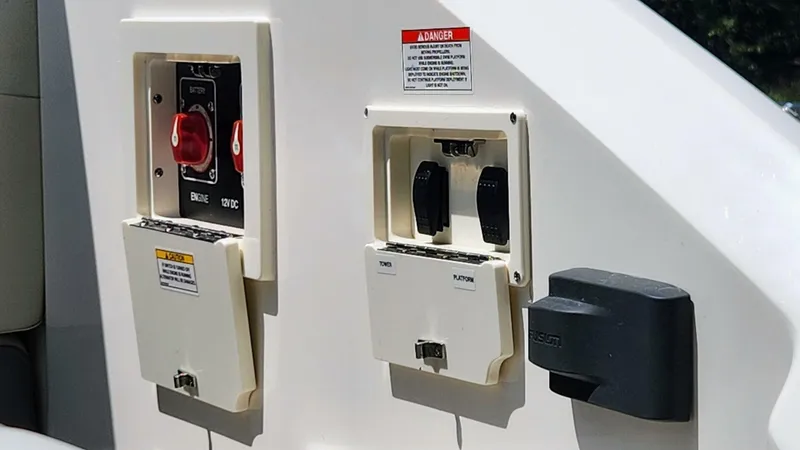 Slide: The Image of Control panel on a 2021 Sea Ray SLX 250 boat, featuring switches and safety warnings. - 31