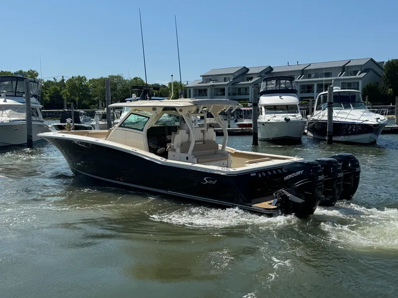 Slide: The Image of 2018 Scout 380 LXF boat with triple Mercury engines in a marina setting. - 1