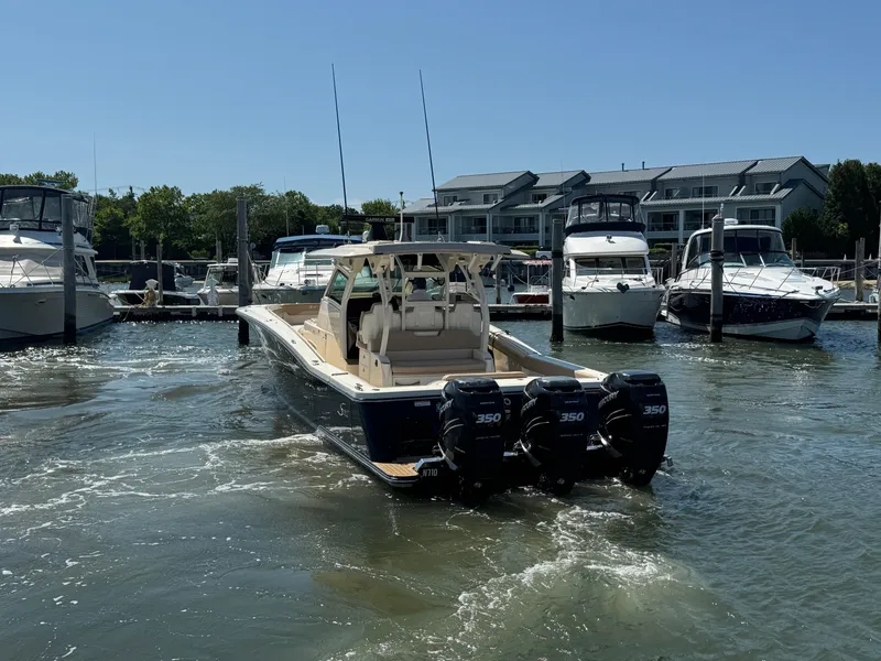 Slide: The Image of 2018 Scout 380 LXF boat with triple 350 engines docked at marina. - 10