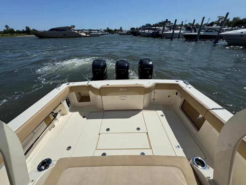 Slide: The Image of 2018 Scout 380 LXF boat with triple engines, docked in a marina. - 14