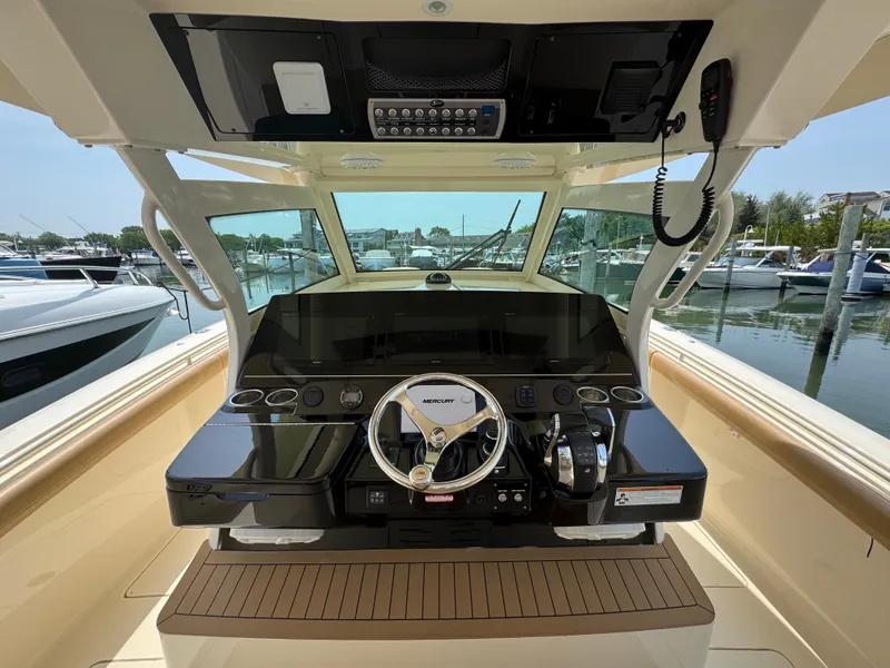 Slide: The Image of 2018 Scout 380 LXF boat helm with advanced controls and marina view. - 17