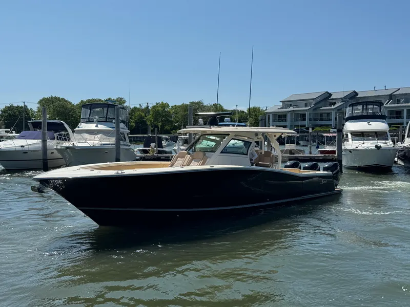 Slide: The Image of 2018 Scout 380 LXF boat docked in a marina with other vessels. - 3