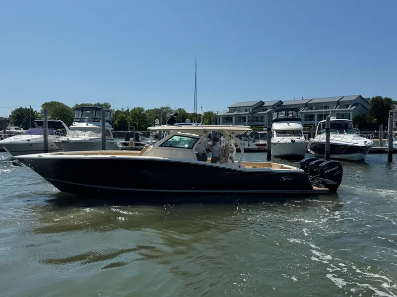 Slide: The Image of 2018 Scout 380 LXF boat docked at marina with other vessels in background. - 4