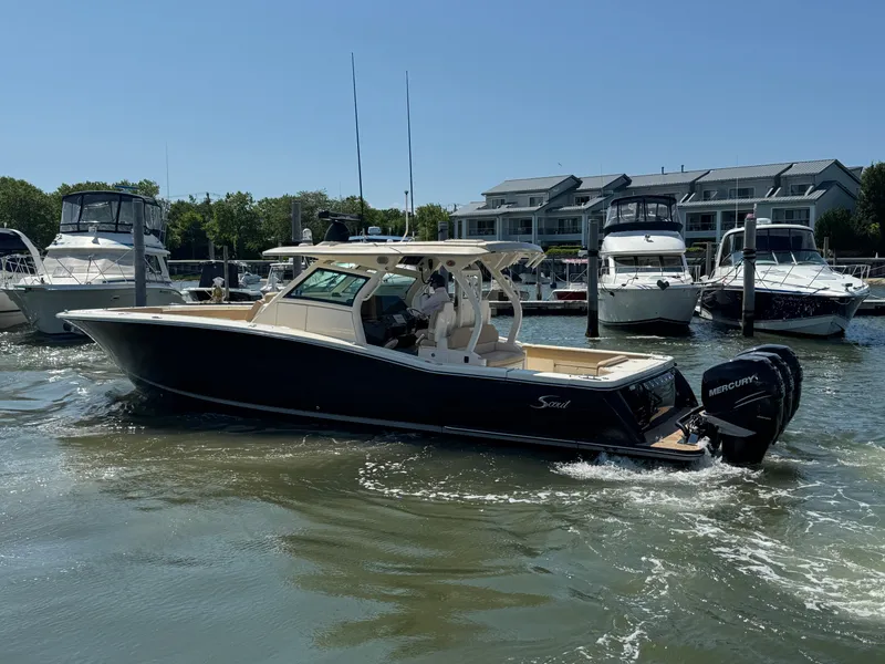 Slide: The Image of 2018 Scout 380 LXF boat docked in marina with other vessels. - 9