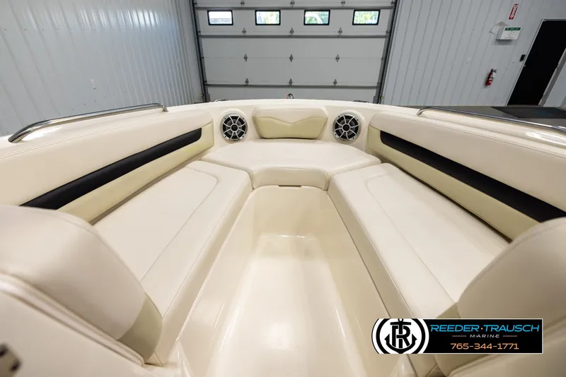 Slide: The Image of 2016 Chaparral 216 SSi boat interior with beige seating and speakers in a garage. - 14