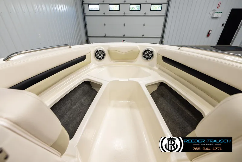Slide: The Image of 2016 Chaparral 216 SSi boat interior with beige seating and speakers in a garage. - 15
