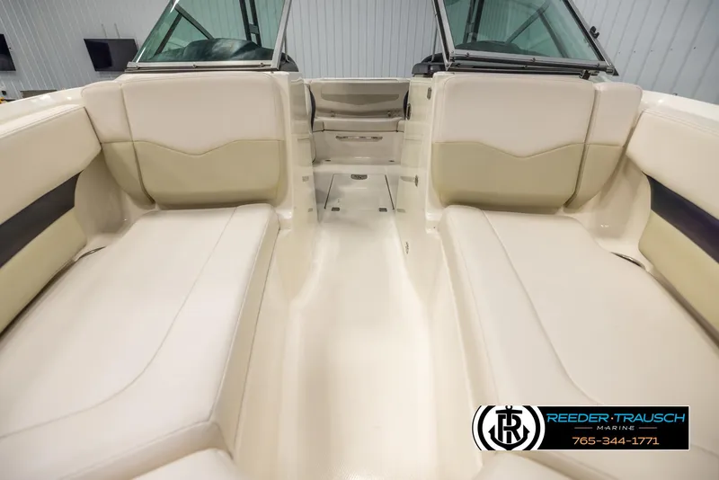 Slide: The Image of 2016 Chaparral 216 SSi boat interior with beige seating and windshield, showcased by Reeder-Trausch Marine. - 16