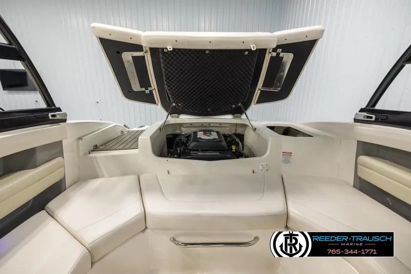 Slide: The Image of 2016 Chaparral 216 SSi boat interior with open engine compartment, showcasing seating and storage. - 20