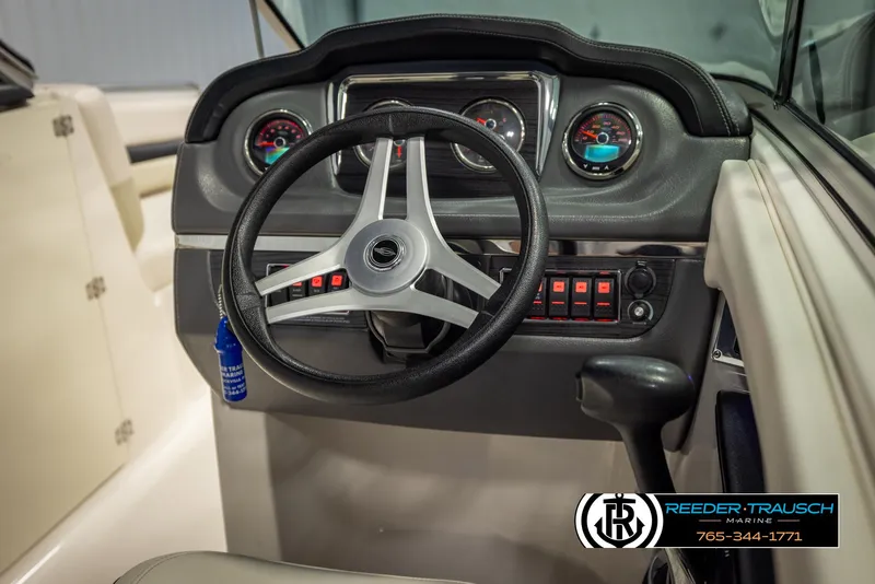Slide: The Image of 2016 Chaparral 216 SSi boat dashboard with steering wheel and control panel. - 27