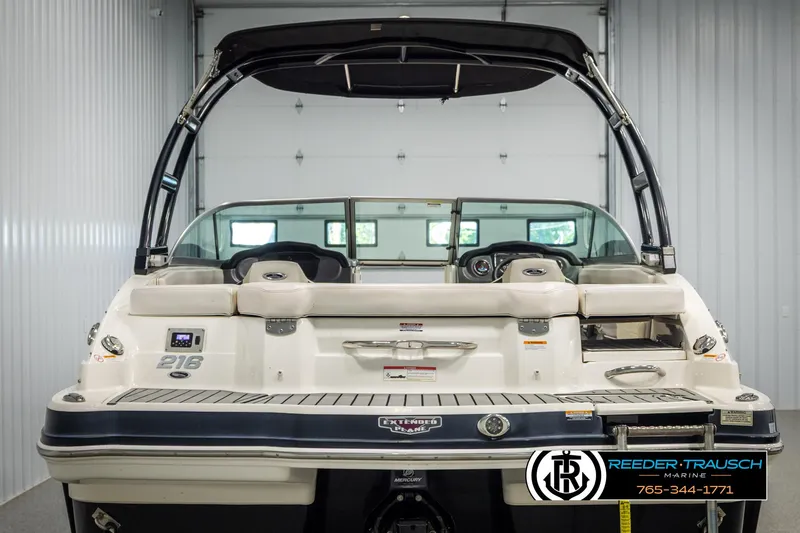 Slide: The Image of 2016 Chaparral 216 SSi boat in showroom, rear view with seating and dashboard. - 6