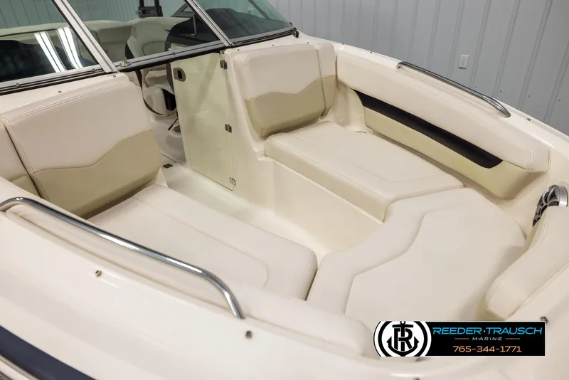 Slide: The Image of 2016 Chaparral 216 SSi boat interior with beige seating and stainless steel accents. - 8