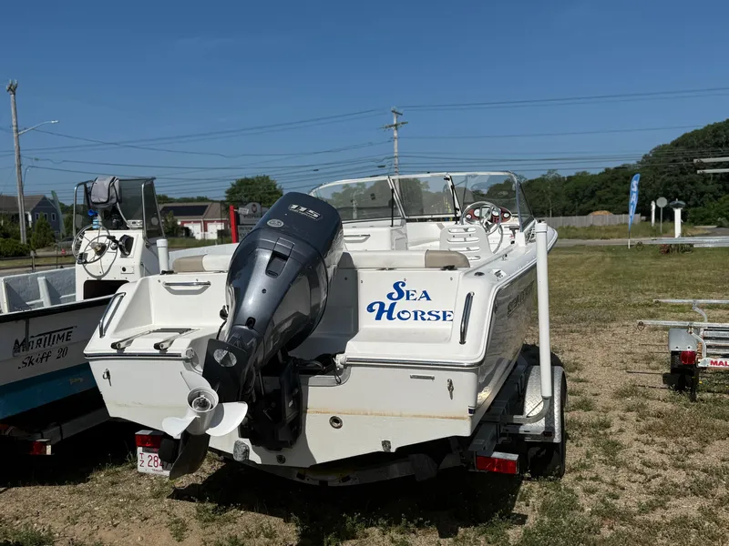 Slide: The Image of 2012 Sea Hunt Escape 188LE boat named "Sea Horse" on a trailer, parked outdoors. - 12
