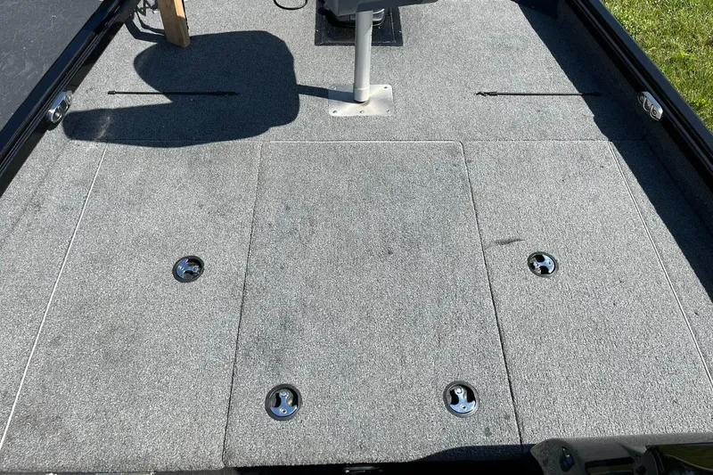 Slide: The Image of 2022 Alumacraft Pro 175 boat deck with gray carpet and storage compartments. - 13