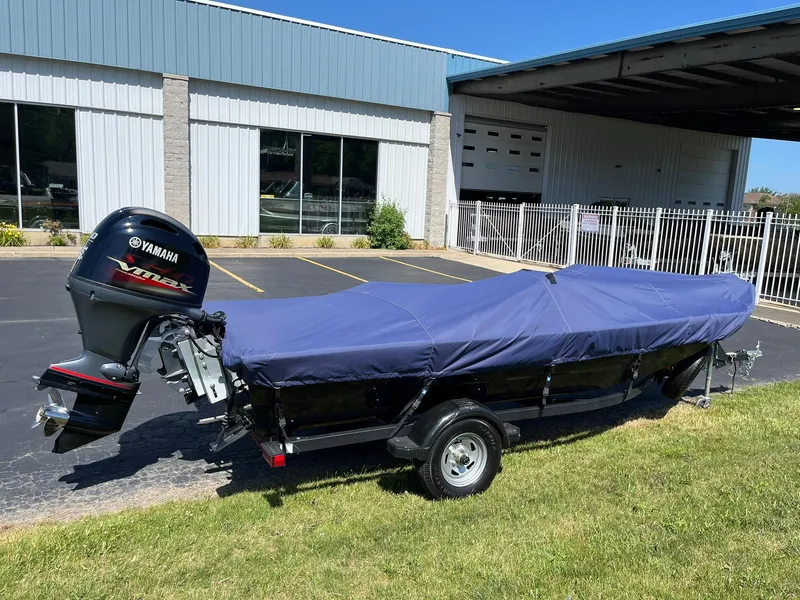 Slide: The Image of 2022 Alumacraft Pro 175 boat with Yamaha engine, covered and parked outside a building. - 34