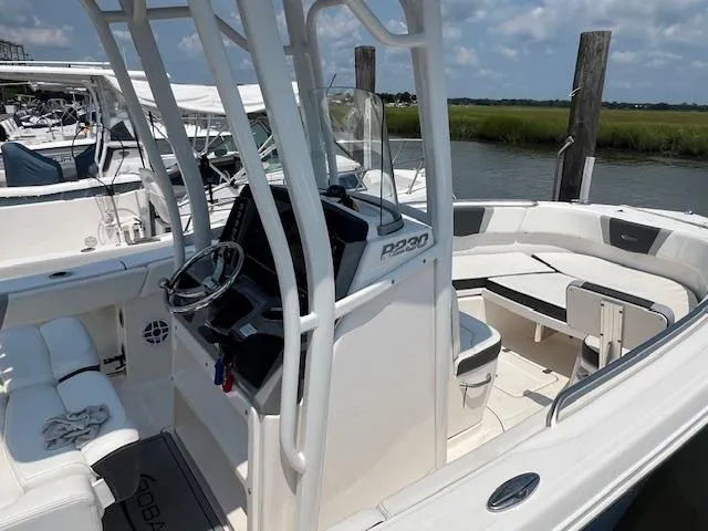 Slide: The Image of 2022 Robalo R230 Center Console boat with sleek design, docked by the water. - 11