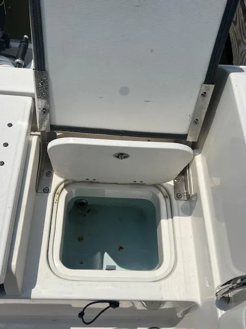 Slide: The Image of 2022 Robalo R230 Center Console livewell with open lid, showcasing interior details. - 13