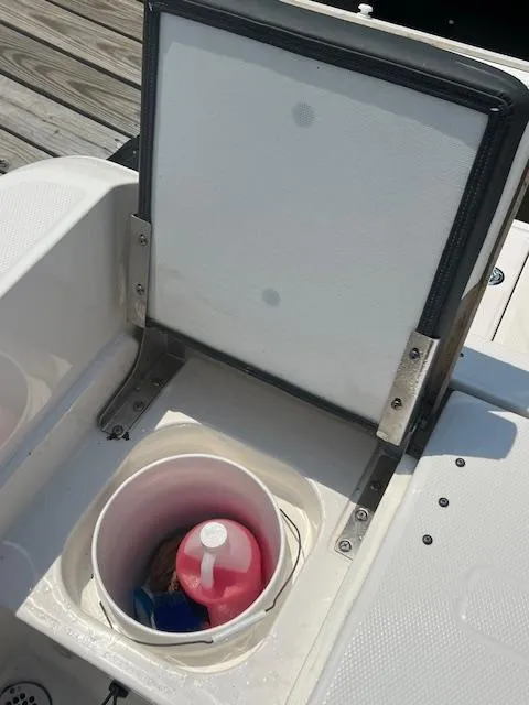 Slide: The Image of 2022 Robalo R230 Center Console boat storage compartment with cleaning supplies. - 14