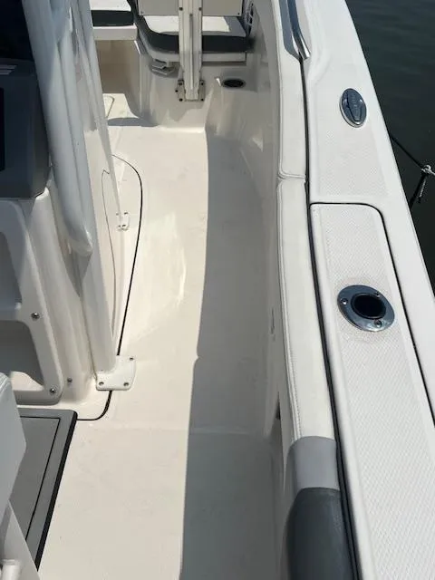 Slide: The Image of 2022 Robalo R230 Center Console boat deck with rod holder and seating area. - 6